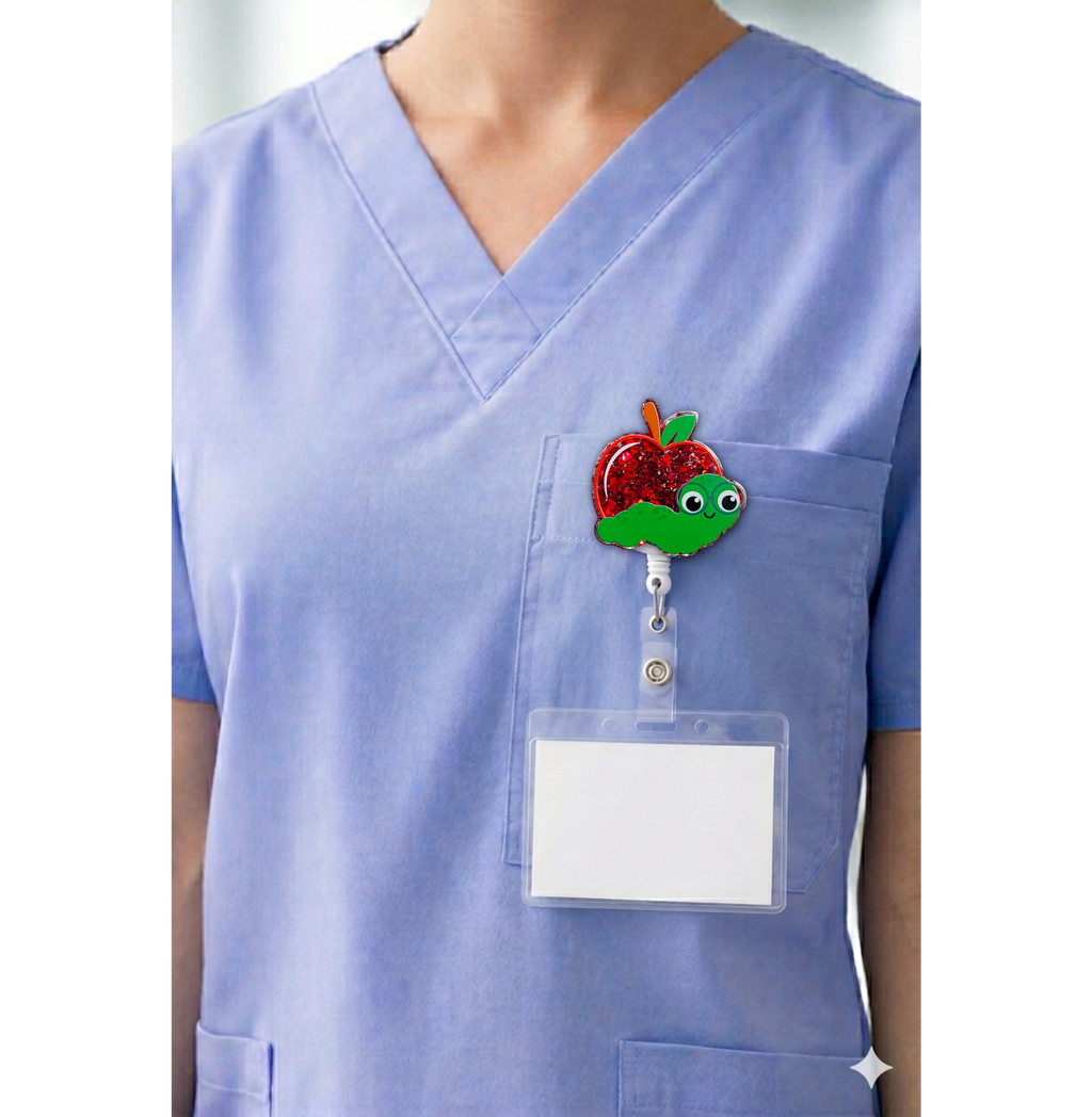 Apple and worm interchangeable badge topper shown on blue scrubs